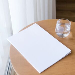 magazine mockup design. blank book mockup on wooden coffee table with glass of water